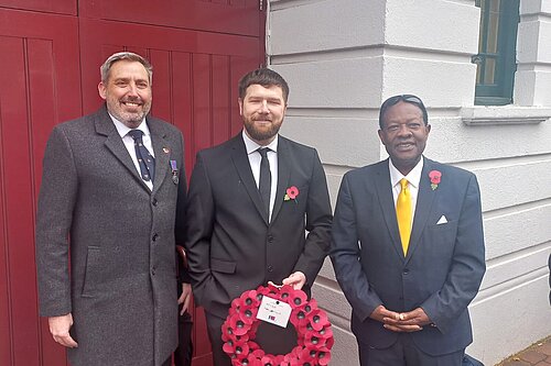 Andrew Thompson, Andrew Fieldsend-Roxborough and Roy Magara stand with poppy wreath