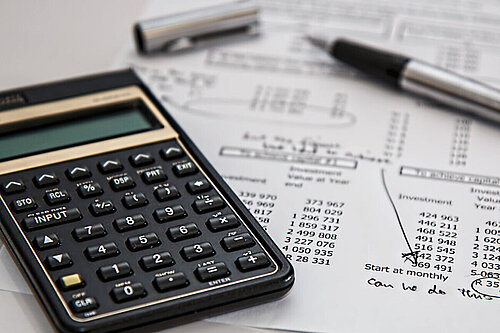 a calculator next to a financial statement